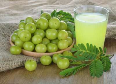 Bottle of pure Amla Juice with fresh Indian gooseberries for natural immunity and digestion support